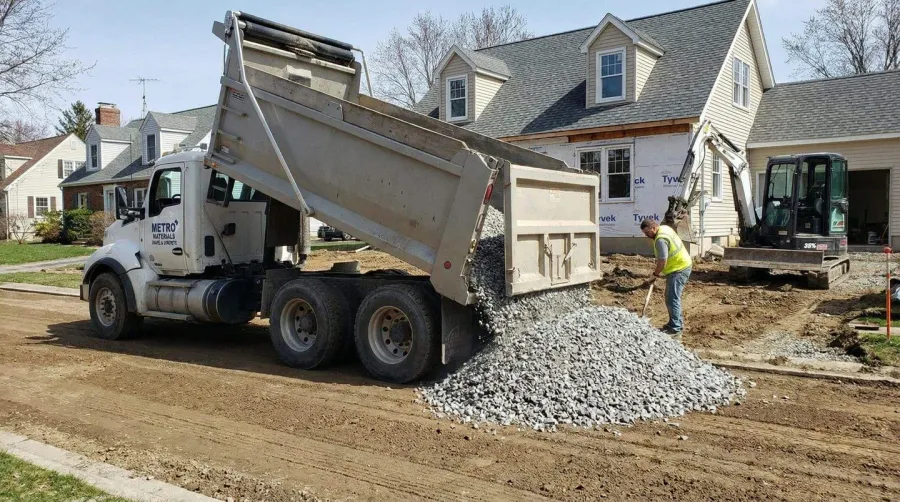 Hello Gravel delivery truck dumping crushed concrete at a residential driveway project
