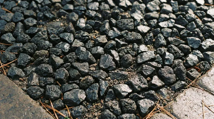 Black basalt gravel driveway installation close-up texture