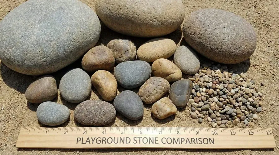 Close-up comparison showing different river rock sizes from pebbles to cobbles to small boulders