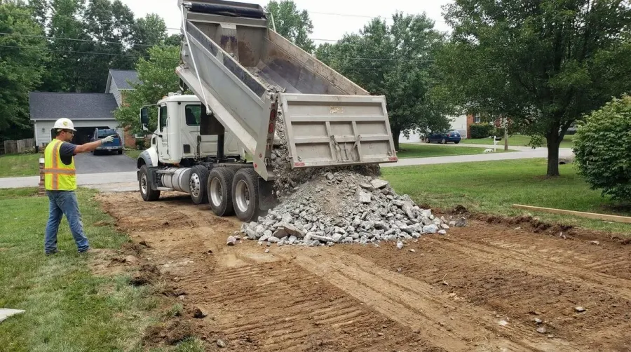 driveway installation showing crushed concrete being spread and compacted