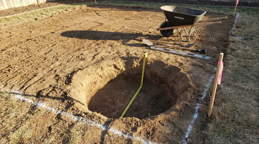 Excavated fire pit area showing depth and cleared ground