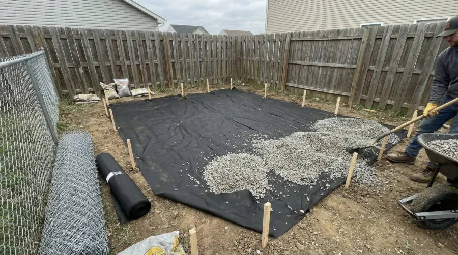 installation process showing landscape fabric and gravel spreading