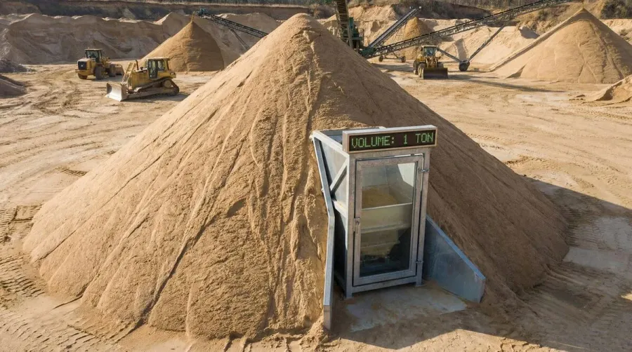 large pile of sand with measuring scale showing one ton volume