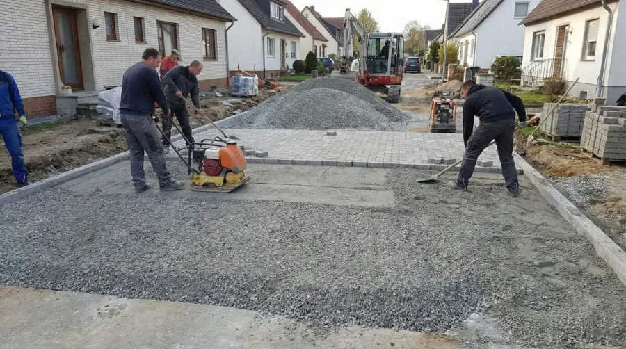 Construction site with crushed concrete road base material, workers and equipment