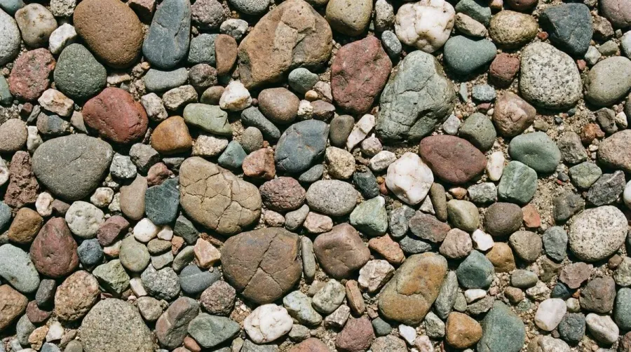Close-up of various pebble sizes and colors on driveway surface
