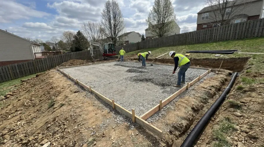 Shed foundation installation showing proper grading and drainage setup