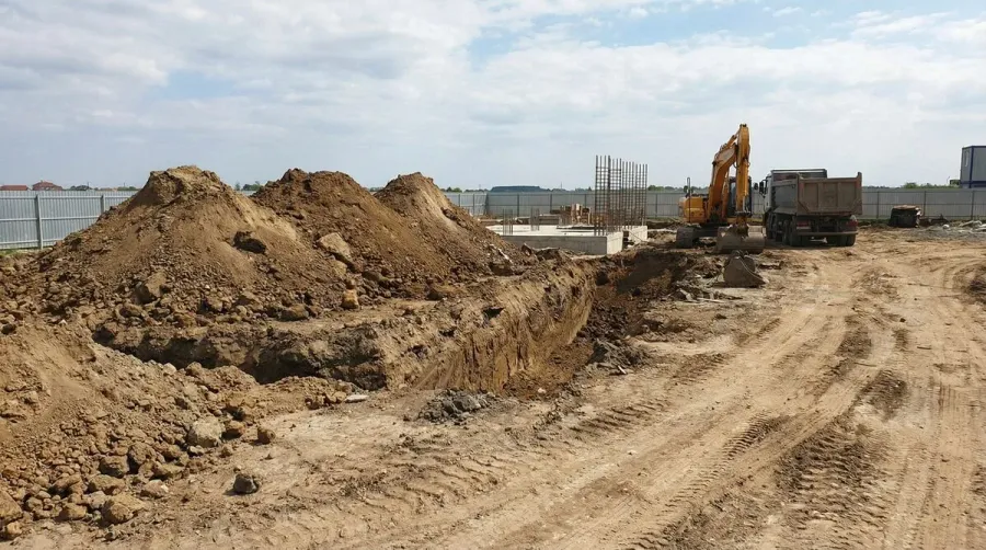 Construction site with excavated dirt piles ready for pickup