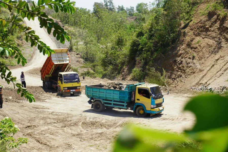 Dump truck delivering river rock to residential property