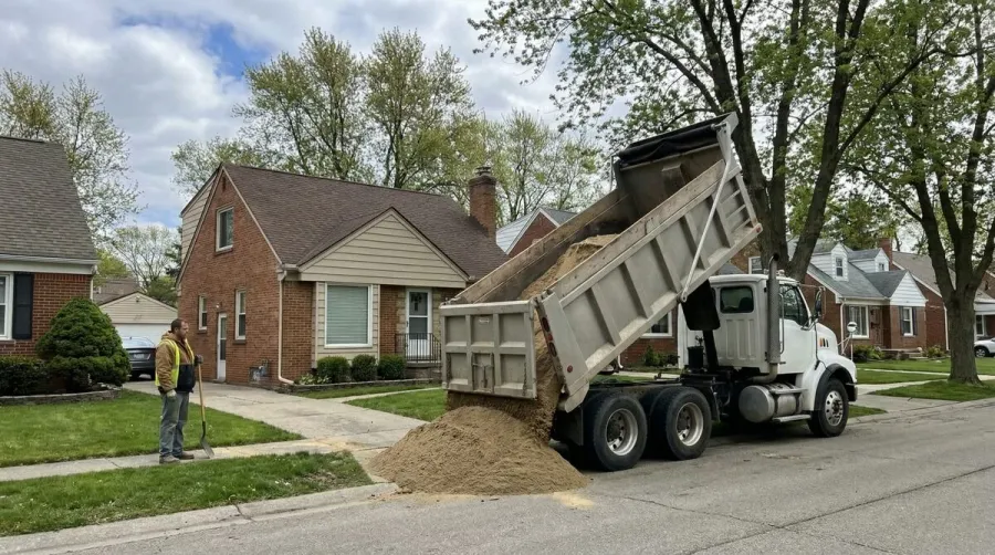 Sand delivery truck delivering materials to a residential property in Michigan