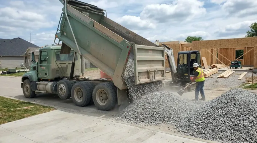 Limestone gravel delivery truck at residential site