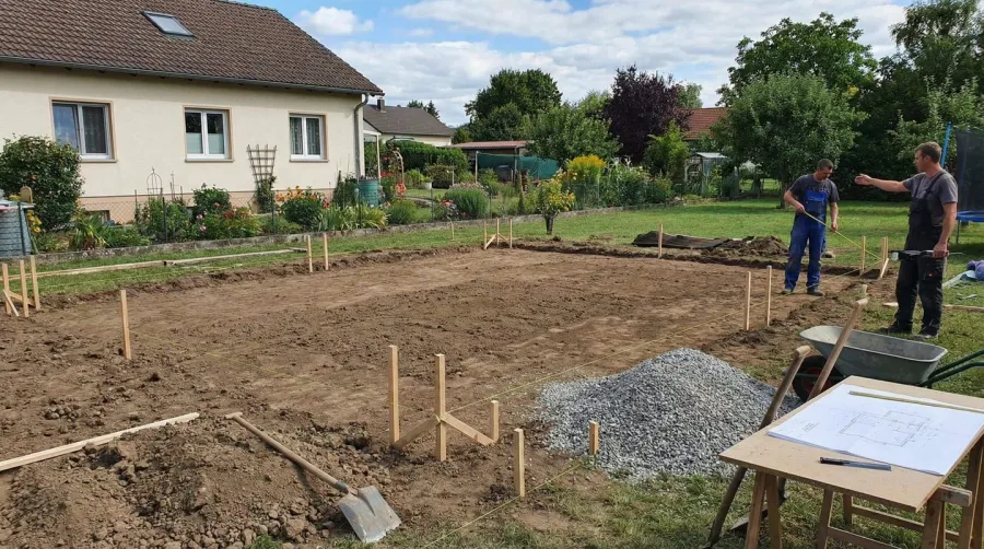 Marking patio area with stakes and string for gravel patio installation