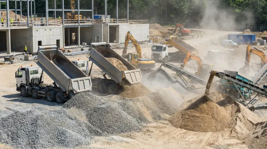 construction site with bulk aggregate materials being delivered by truck