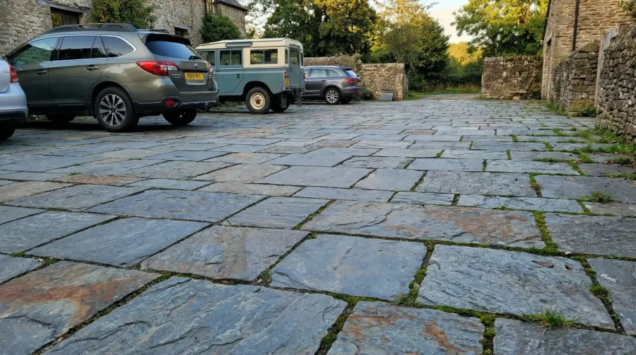 Bluestone parking area with cars parked showing natural stone texture
