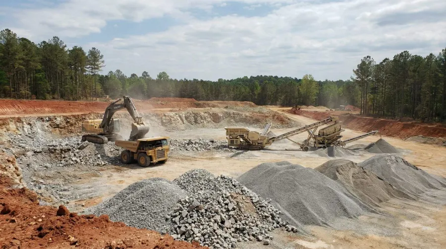 Alabama quarry operation showing limestone extraction with heavy machinery and sorted aggregate piles