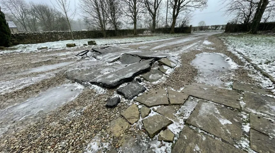 Weather damaged driveway showing frost heave effects
