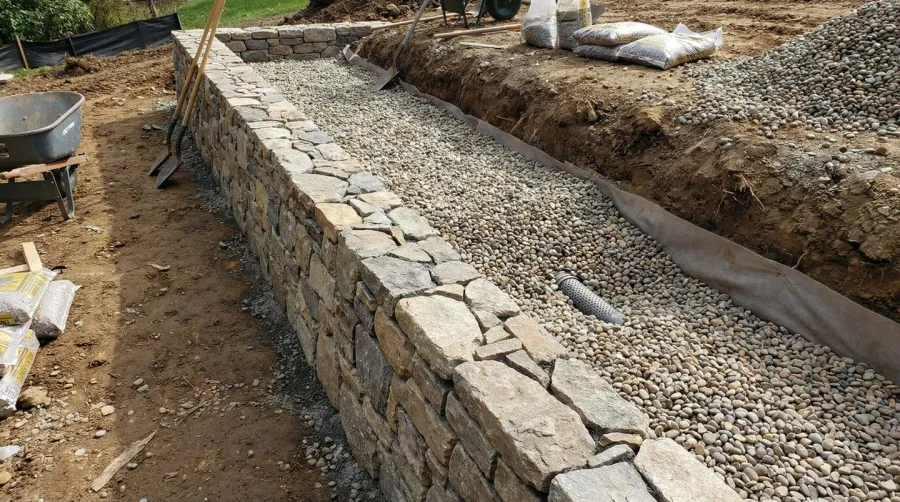 Retaining wall with pea gravel drainage system